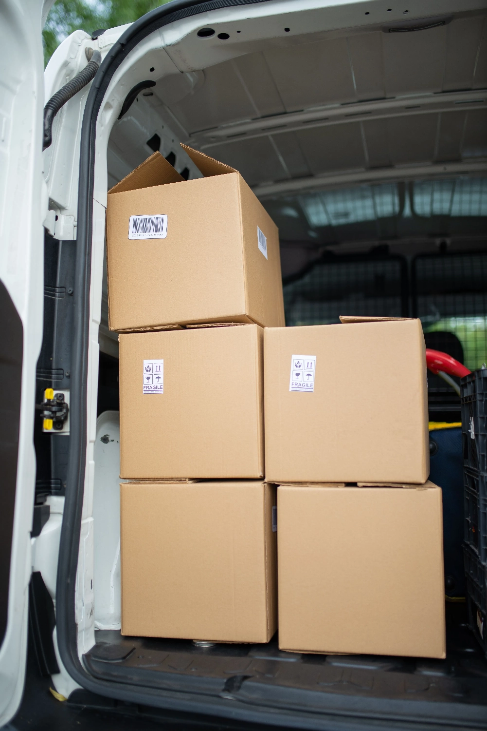 Jova – Logistikdienstleistungen – Dieses Bild zeigt einen Stapel Kartons in einem offenen Lieferwagen, der häufig zur Veranschaulichung von Logistik- und Versandkonzepten verwendet wird.