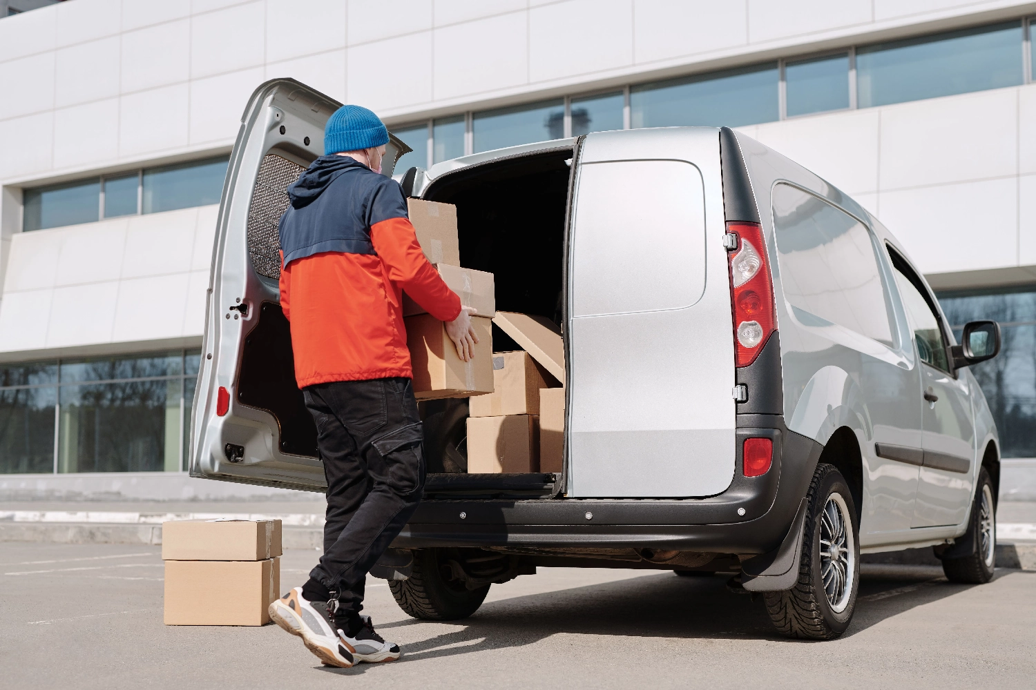 Jova – Logistikdienstleistungen – Dieses Bild zeigt einen Renault Kangoo-Transporter, der mit Frachtboxen beladen wird.